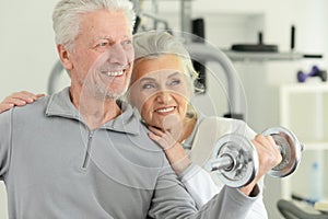 Active smiling senior couple exercising in gym
