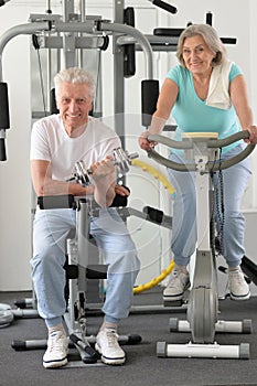 Active smiling senior couple exercising in gym