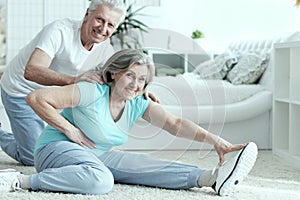 Active smiling senior couple exercising in gym