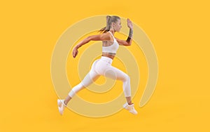active sport girl runner running on yellow background