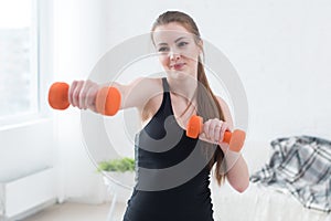 Active sportive athletic woman boxing dumbbells