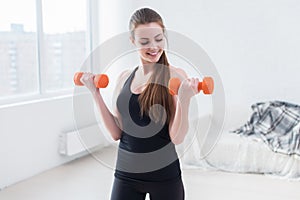 Active sportive athletic woman with dumbbells