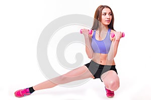 Active sportive athletic woman with dumbbells pumping up muscles biceps