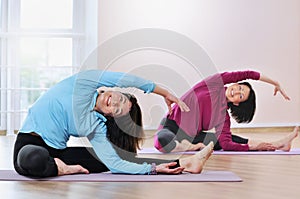 Active sportive mature women doing exercise in fitness studio