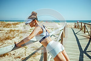 Active sports woman on ocean coast doing pushups