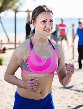 Active sportswoman running on the beach