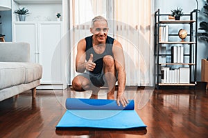 Active and sporty senior man preparing fitness mat. Clout