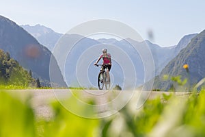 Active sporty woman riding mountain bike in nature.