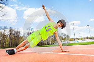 Active teenage boy holding a side plank outdoors