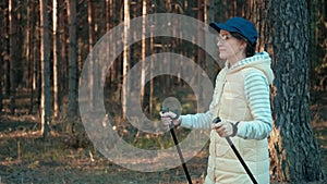 Active tourist woman in cap and glasses during nordic walking. Medium shot on RED camera