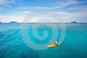 active travel, tourist on kayak paddling on paradise beach in Thailand