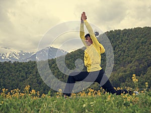 Active way of life.Young woman doing yoga exercises in the mountains
