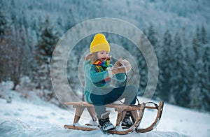 Active winter outdoors games for kids. Happy Christmas vacation concept. Boy enjoying winter, playing with sleigh ride