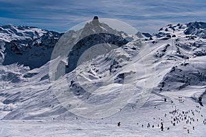 Active winter vacation, skiers and snowboarders going down the slopes.