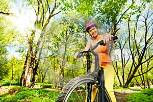 Active woman during the bike ride in sunny forest