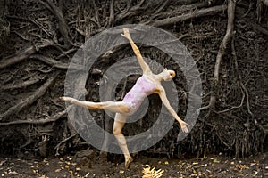 Active woman dancing with overturned tree roots in Manchester, Connecticut