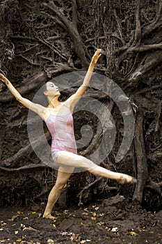 Active woman dancing with overturned tree roots in Manchester, Connecticut