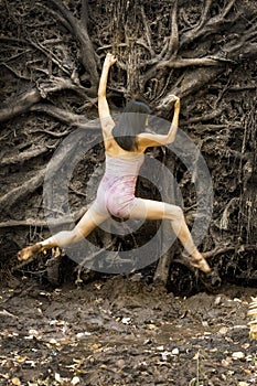 Active woman dancing with overturned tree roots in Manchester, Connecticut