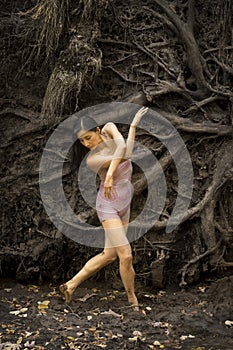 Active woman dancing with overturned tree roots in Manchester, Connecticut