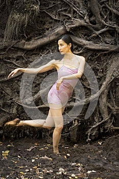 Active woman dancing with overturned tree roots in Manchester, Connecticut