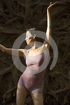 Active woman dancing with overturned tree roots in Manchester, Connecticut