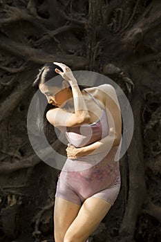 Active woman dancing with overturned tree roots in Manchester, Connecticut