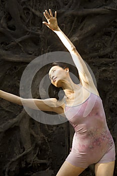 Active woman dancing with overturned tree roots in Manchester, Connecticut