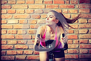 Active woman doing sport biking.