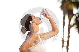 Active woman drinking water after exercise workout