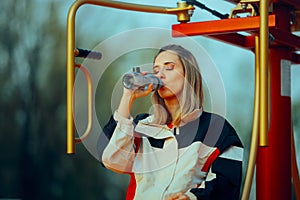 Active Woman Drinking Water After Exercising in a Public Park