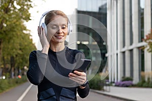 Active woman enjoying music on headphones outdoors in the city