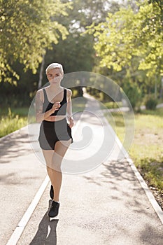 Active woman enjoying a run on a sunny forest pathway