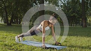 Active woman exercising with fitness push-ups bars