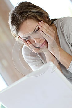 Active woman getting upset in front of laptop photo
