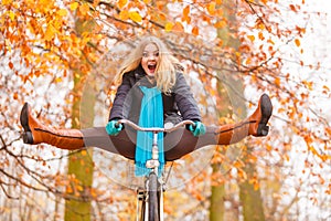 Active woman having fun riding bike in autumn park