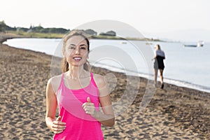 Active woman jogging by a beach