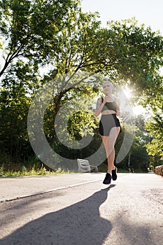 Active woman jogging in a park at sunrise