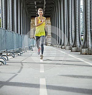 Active woman jogging on Pont de Bir-Hakeim bridge in Paris