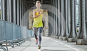 Active woman jogging on Pont de Bir-Hakeim bridge in Paris
