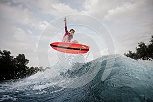 Active woman jumping up the blue slashing wave against the grey