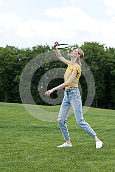 Active woman playing badminton game in park, summertime concept