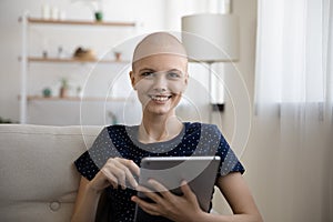 Active woman recovering from oncology posing on couch holding pad