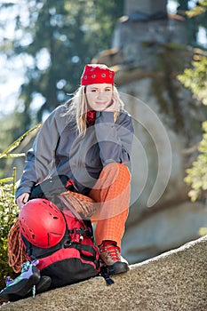 Active woman rock climbing sitting backpack