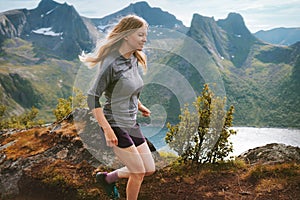 Active woman running in mountains of Norway outdoor travel adventure hiking healthy lifestyle trip