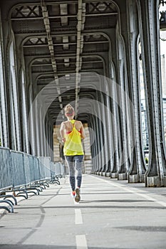 Active woman running on Pont de Bir-Hakeim bridge in Paris