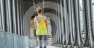 Active woman running on Pont de Bir-Hakeim bridge in Paris