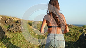 Active woman running to banawa beach cliff edge