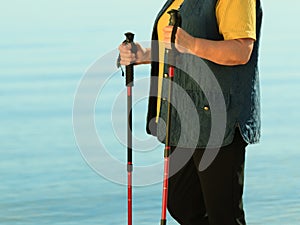 Active woman senior nordic walking on a beach