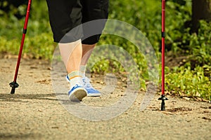 Active woman senior nordic walking in park. legs