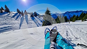 Active woman in snow shoes having a tea break with scenic view on snow capped mountain peaks of Karawanks in Carinthia, Austria.